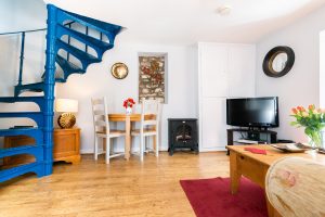 Courtyard Cottage Lounge with spiral stairs. A pet friendly holiday cottage.